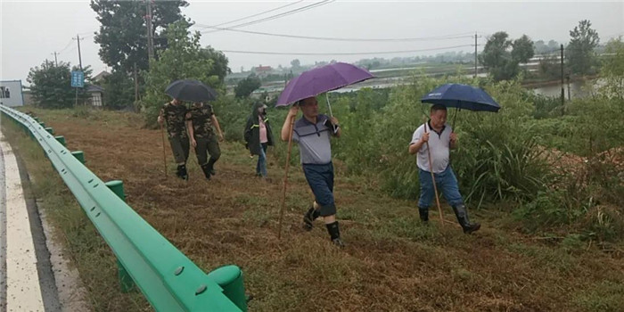 陈新栋（右一）拄着棍子和干警们在湖堤.jpg